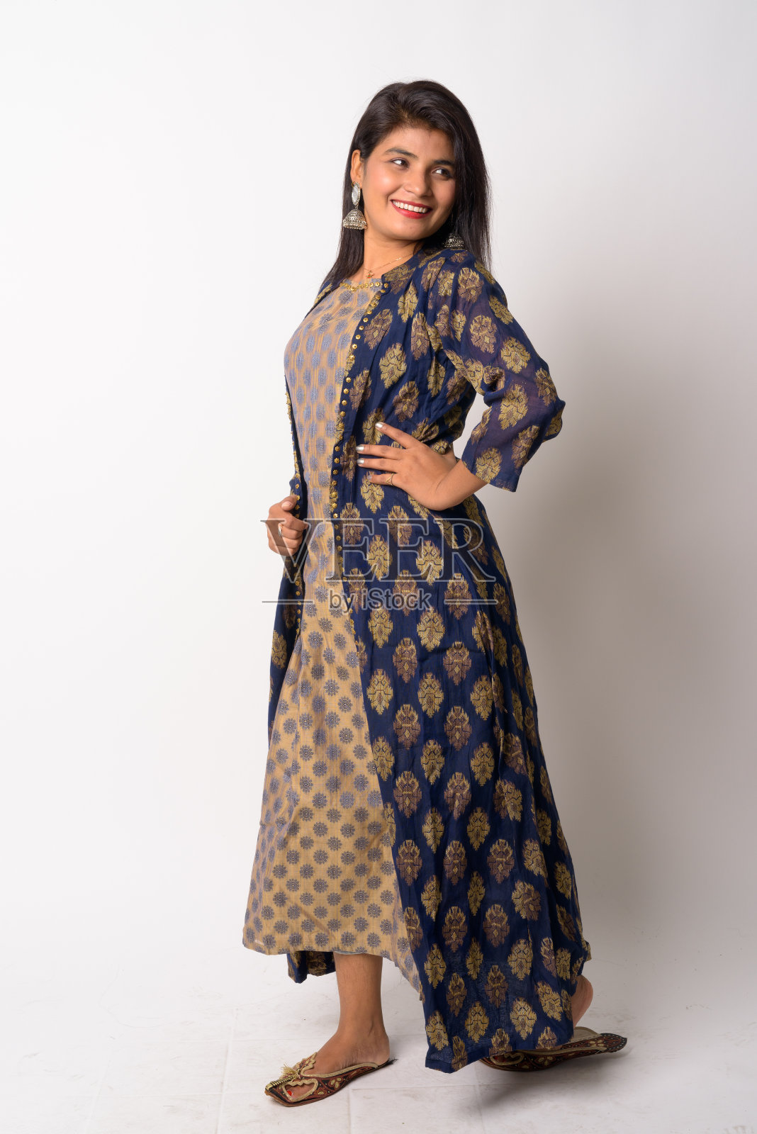 快乐的年轻波斯女子身穿传统服装,回头看全身照照片摄影图片