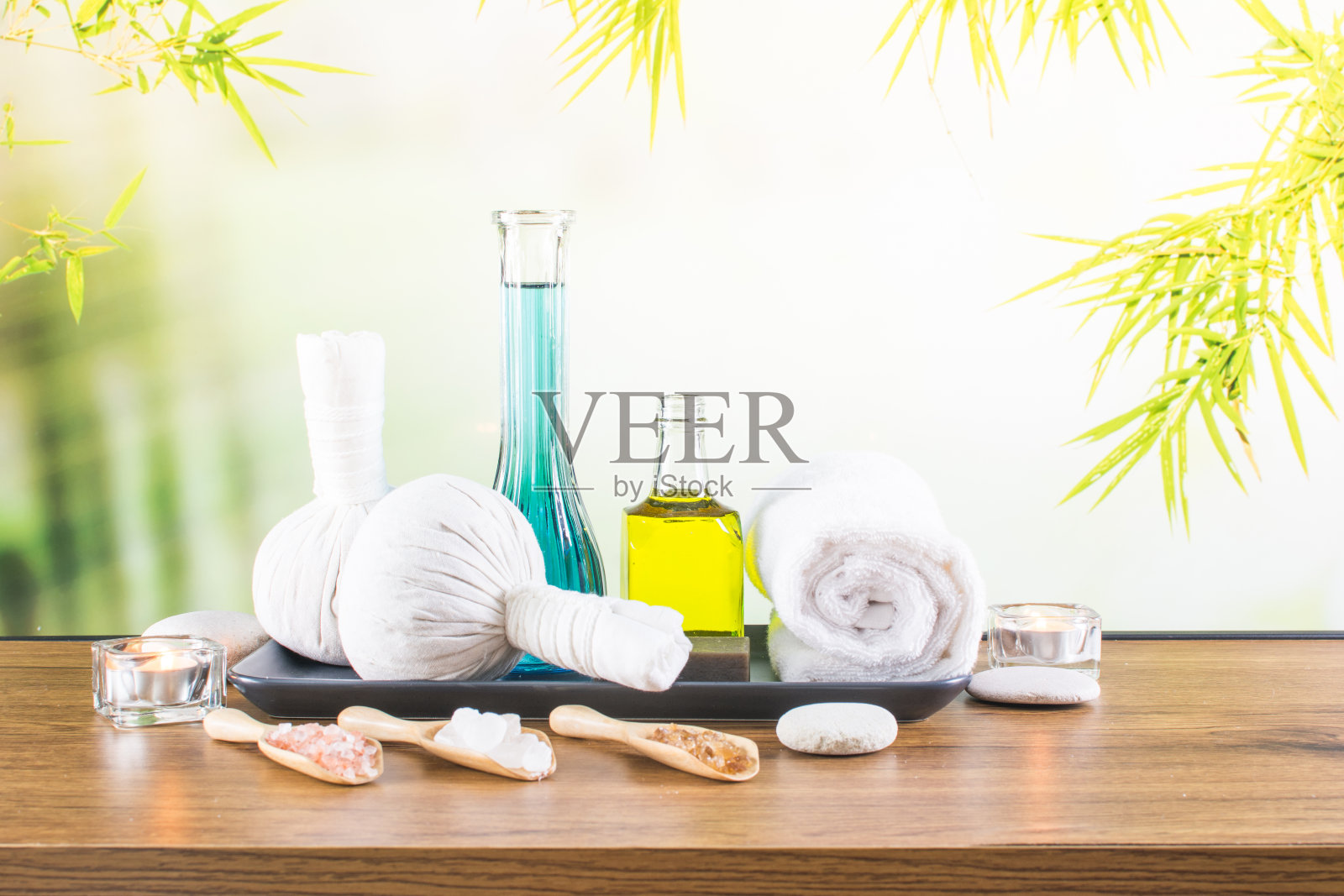 近距离的美容和时尚概念与水疗设置的健康中心。美丽的spa美容产品概念,按摩和芳香疗法油在竹林轻和散照片摄影图片