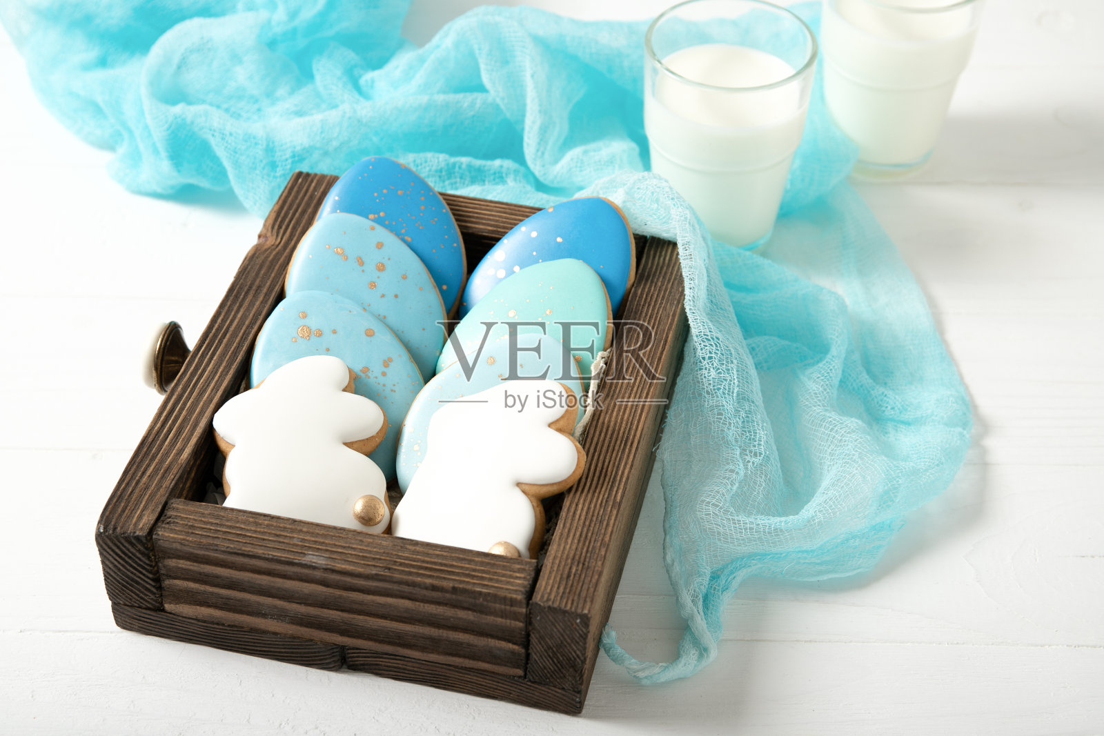 复活节饼干在抽屉里。一杯牛奶。复活节彩蛋。复活节兔子。照片摄影图片
