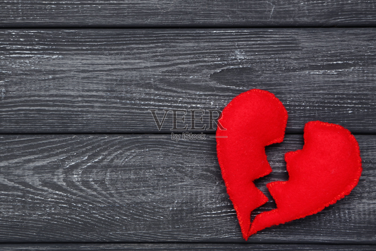 黑色木桌上破碎的红布心照片摄影图片