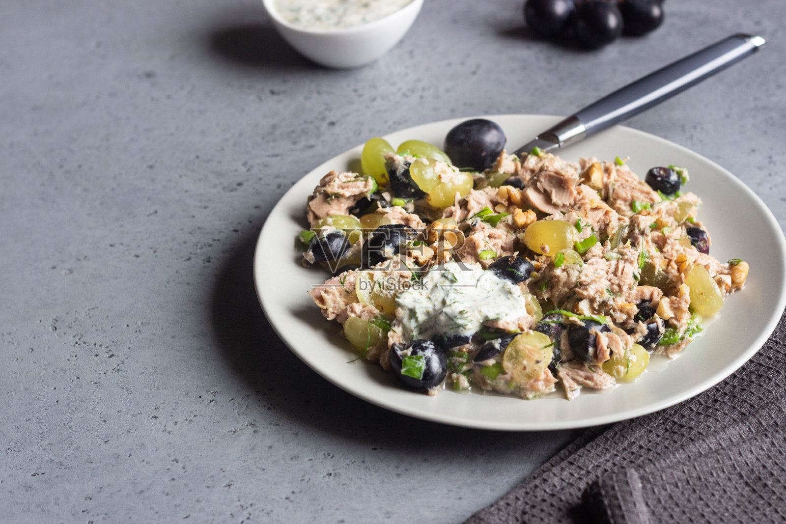 金枪鱼,绿和黑葡萄沙拉配天然酸奶酱。健康和食物。简单的早餐,午餐或晚餐。照片摄影图片