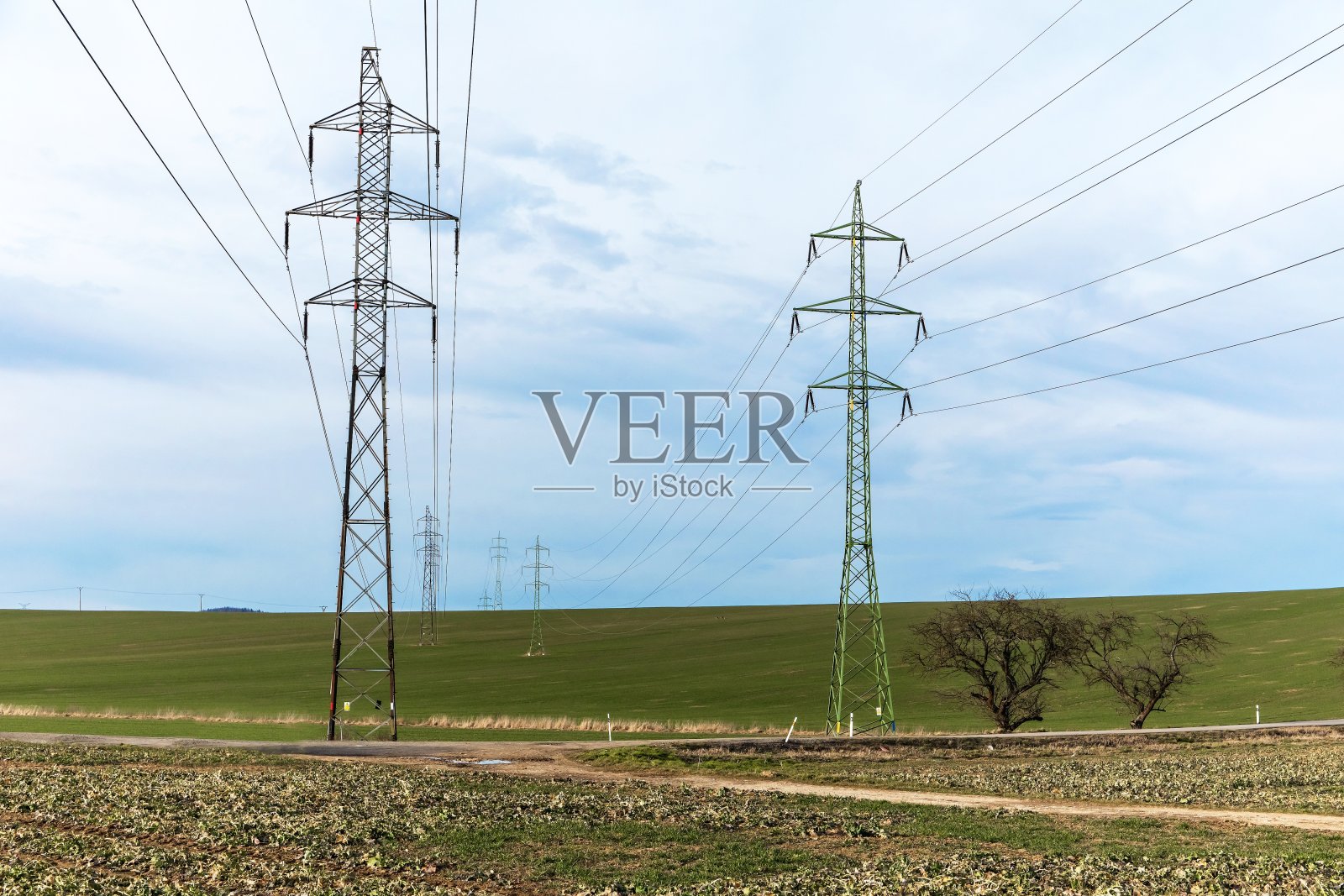 田野里的电线。能量转移。分配电能。工业景观照片摄影图片