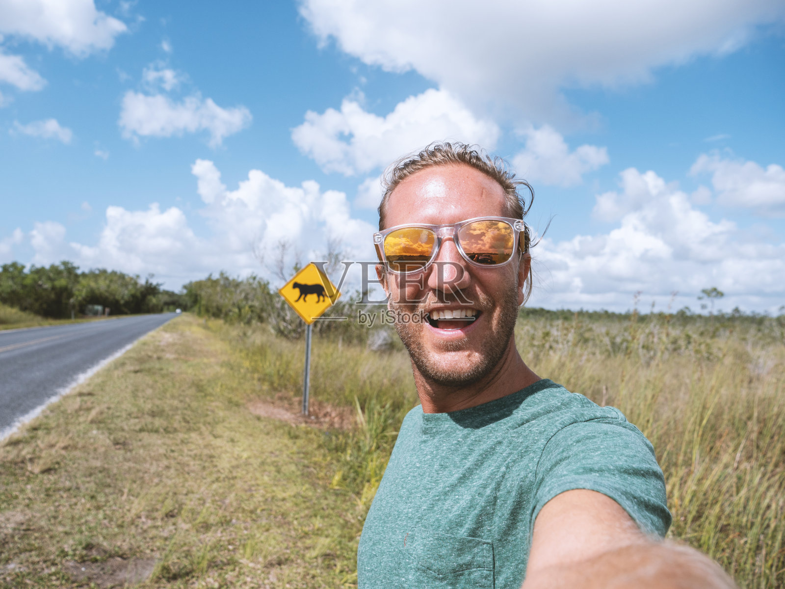 青年在佛罗里达美洲豹警告标志附近的空旷高速公路上自拍照片摄影图片