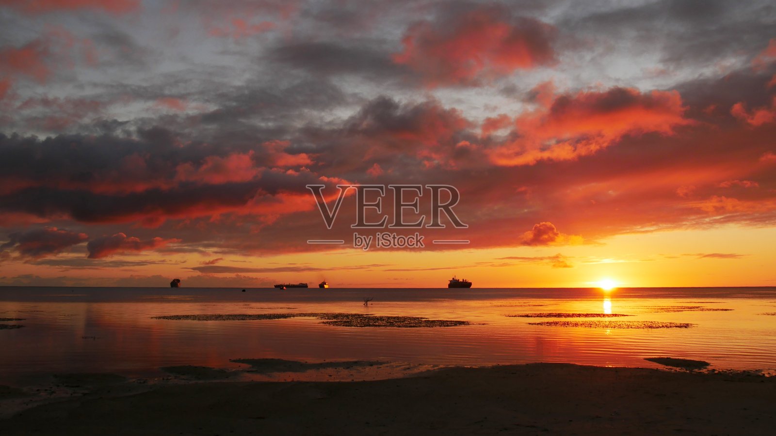 辉煌灿烂的夕阳倒映在北马里亚纳群岛塞班泻湖的水面上。照片摄影图片