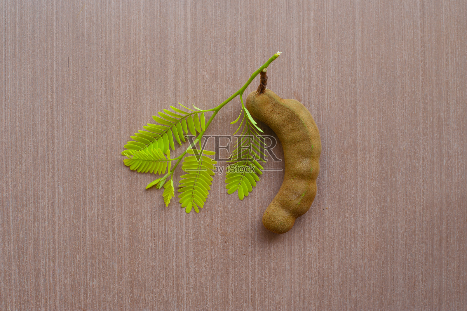 木地板上放着绿叶和罗望子。特写镜头,照片摄影图片