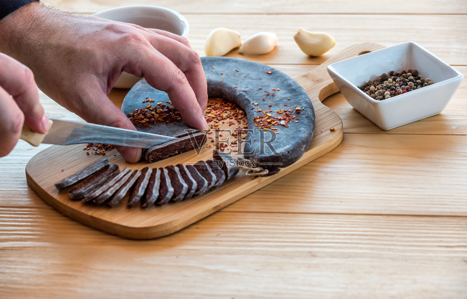 男人双手切割特殊的熨烫过的皮罗特马蹄香肠照片摄影图片