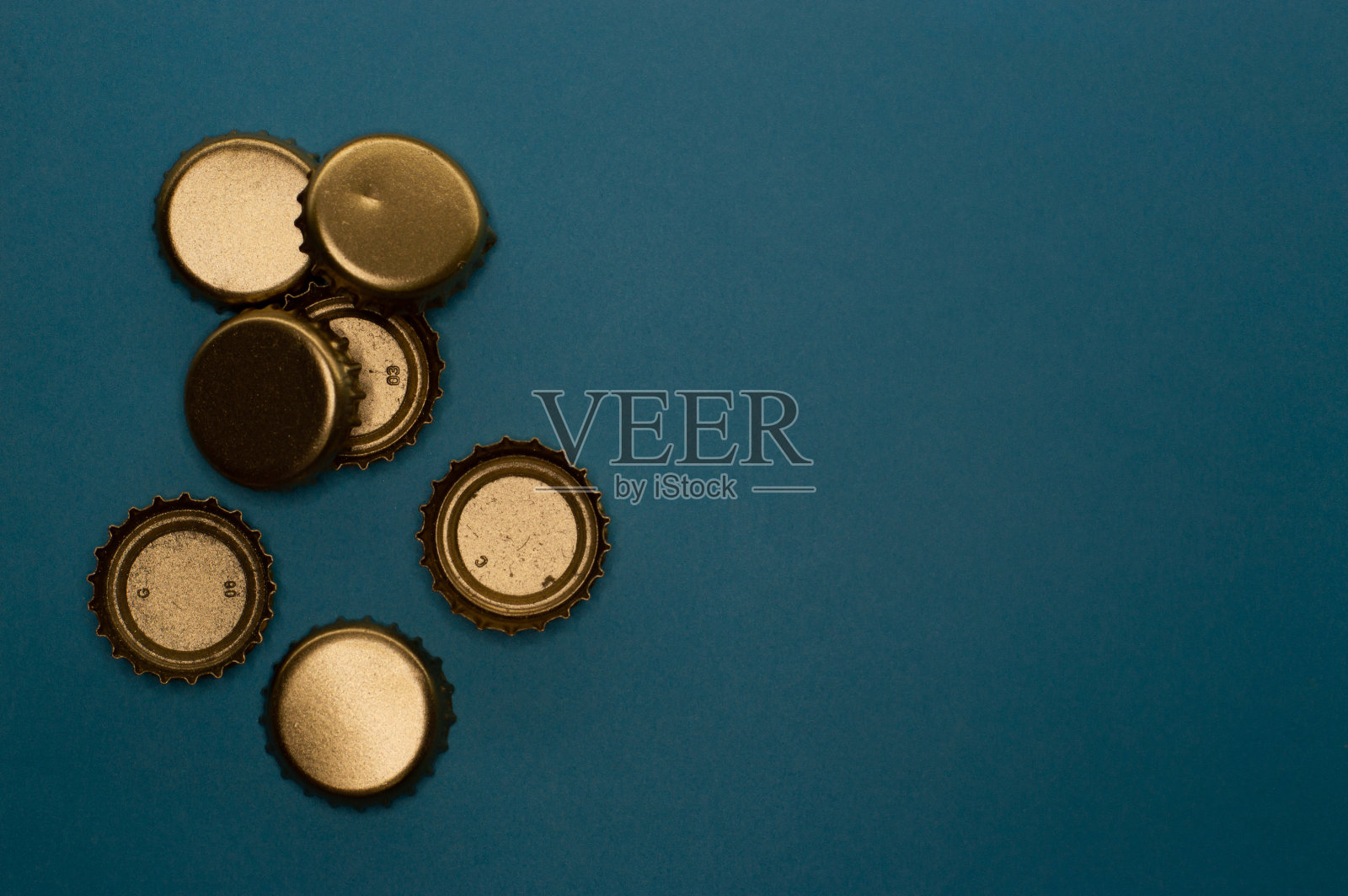 蓝色背景的七组瓶盖照片摄影图片