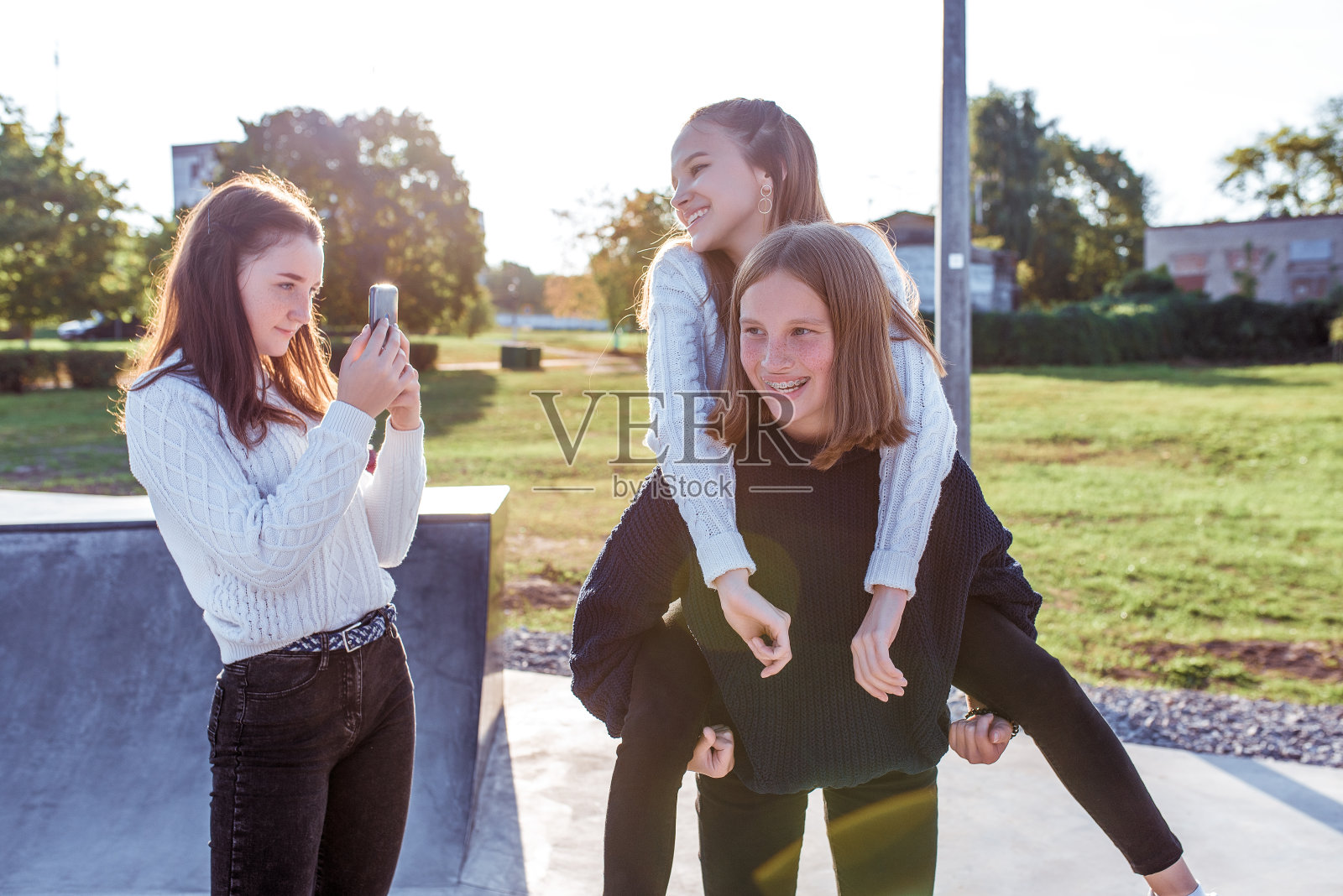 三个年轻女孩用智能手机录制视频。情绪幸福,乐趣,喜悦,微笑,欢笑,大学休息。最好的女朋友,放学后休息照片摄影图片