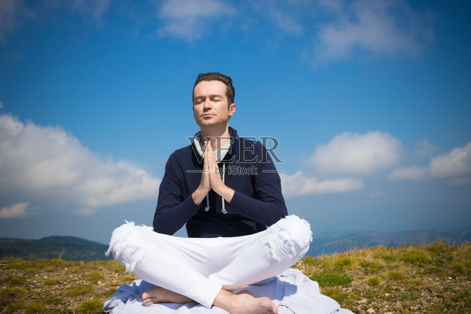 在田野上以合十姿势冥想的男子照片摄影图片