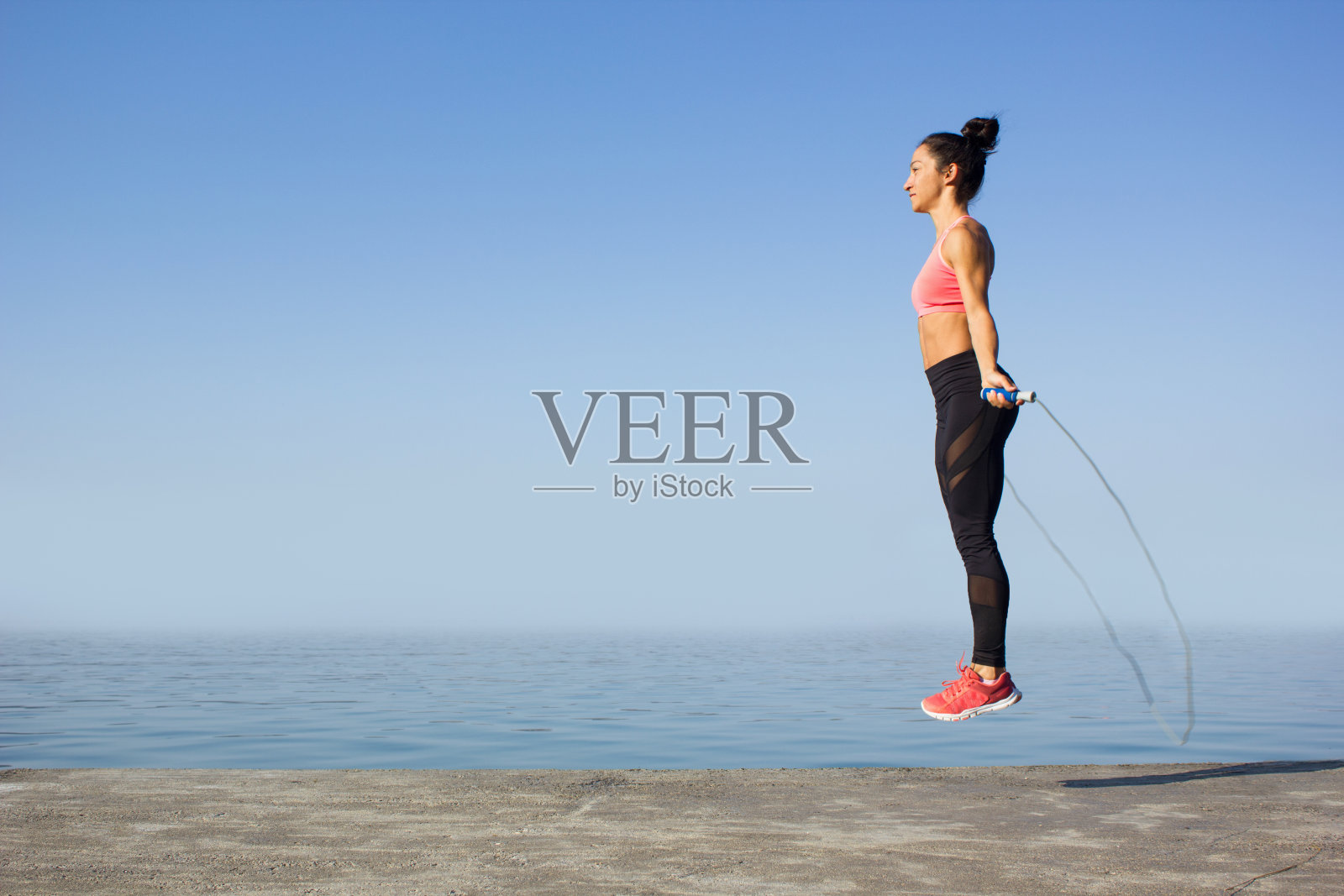 快乐强壮的女人跳绳照片摄影图片