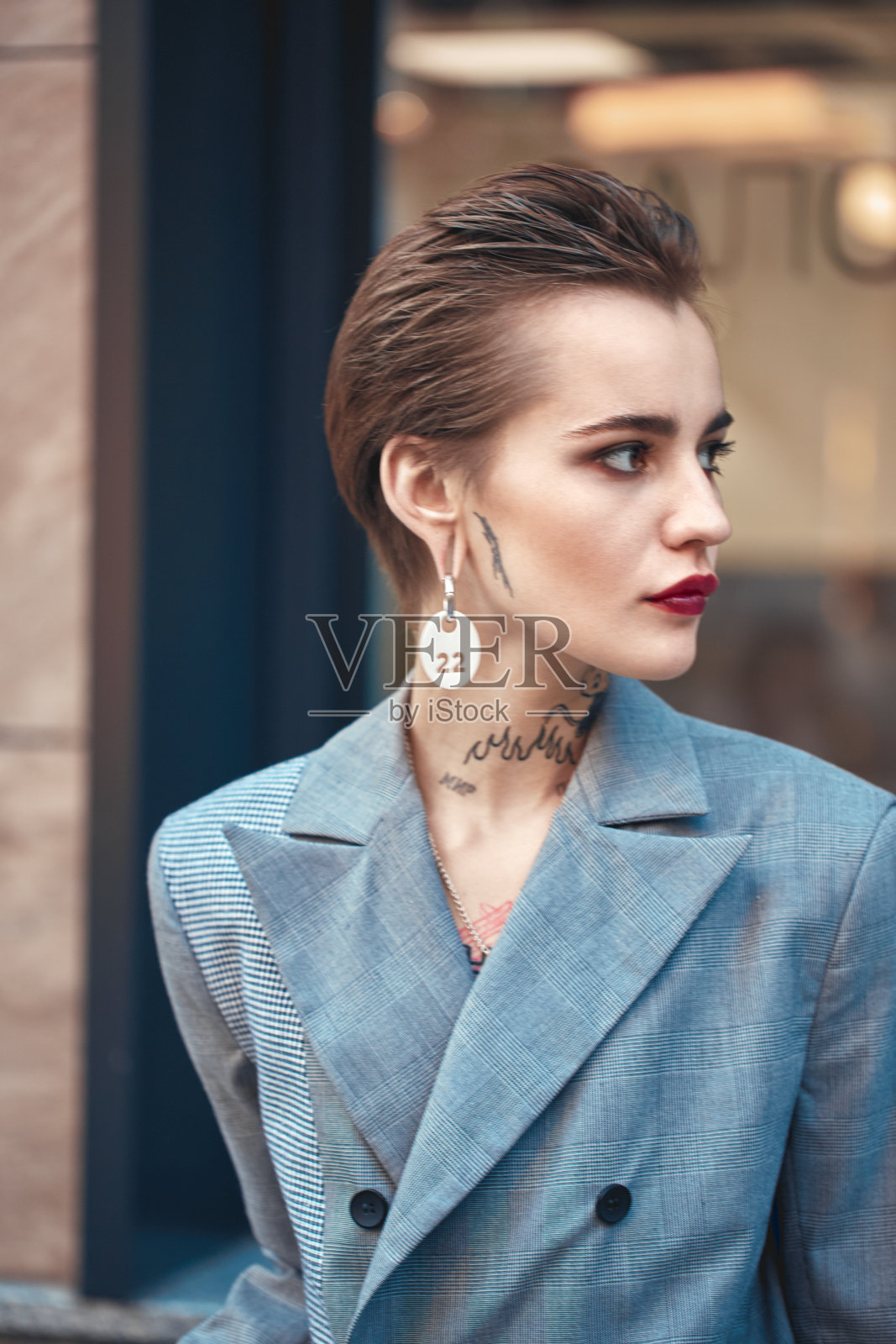 都市风尚:身穿外套的年轻时尚女性在户外好奇地侧目照片摄影图片