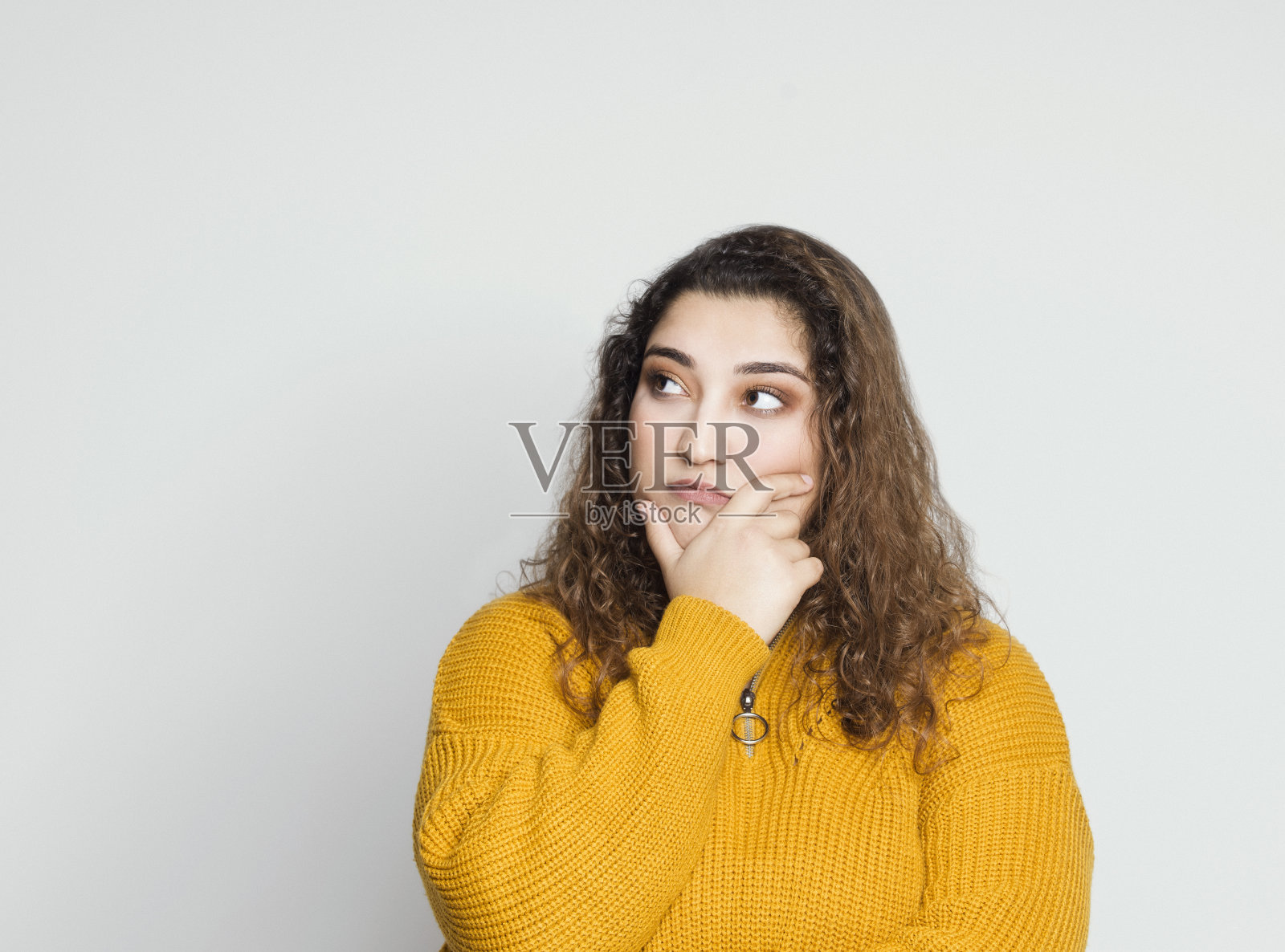 灰色背景上,若有所思的年轻女子肖像照片摄影图片