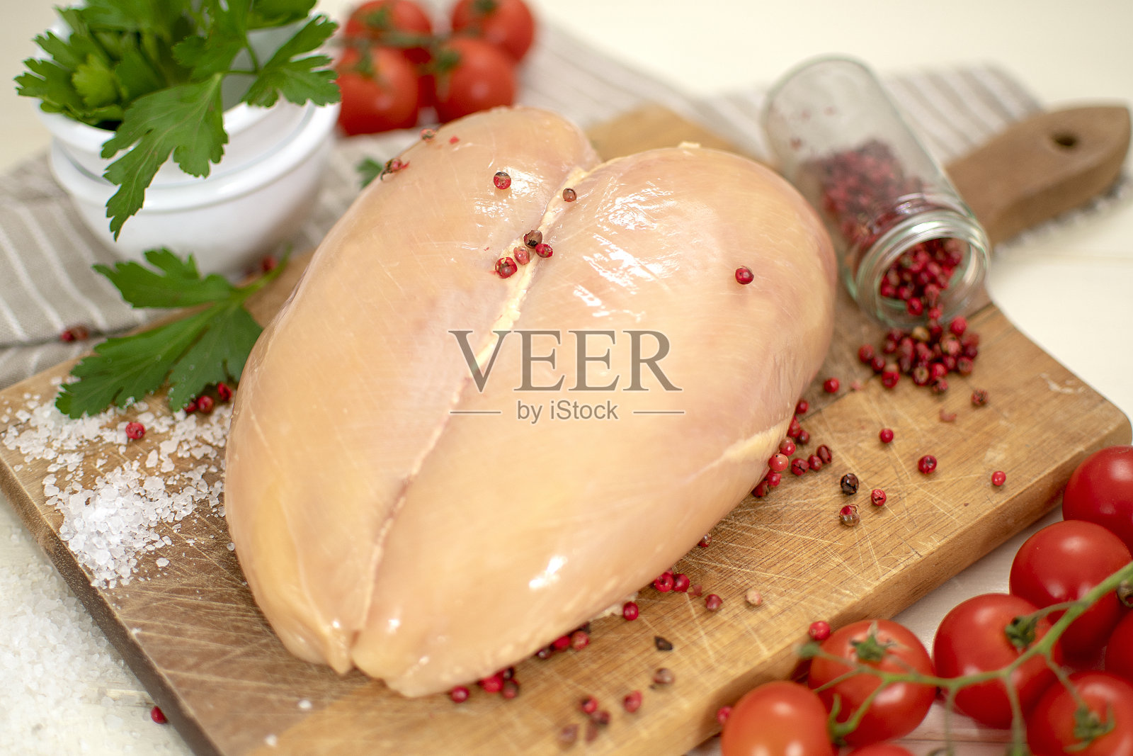 生鸡肉片配红辣椒、欧芹和西红柿。照片摄影图片