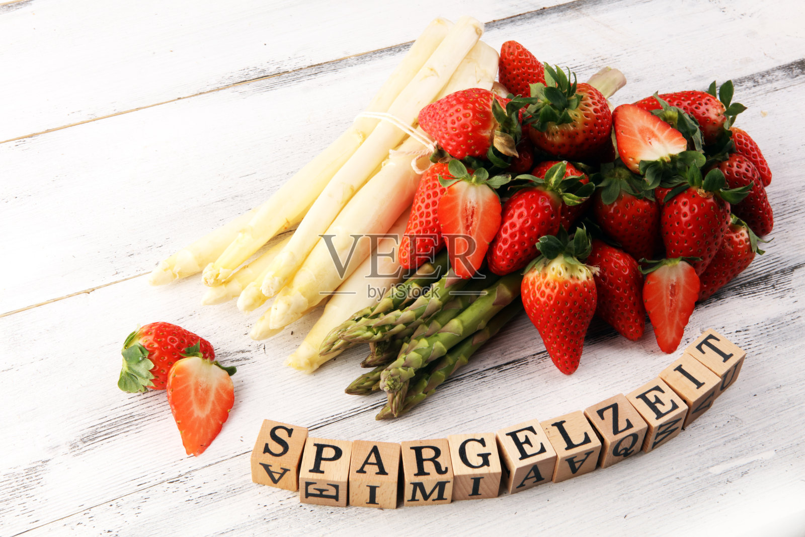 白色和绿色的芦笋与草莓在乡村背景与Spargelzeit木制字母。照片摄影图片