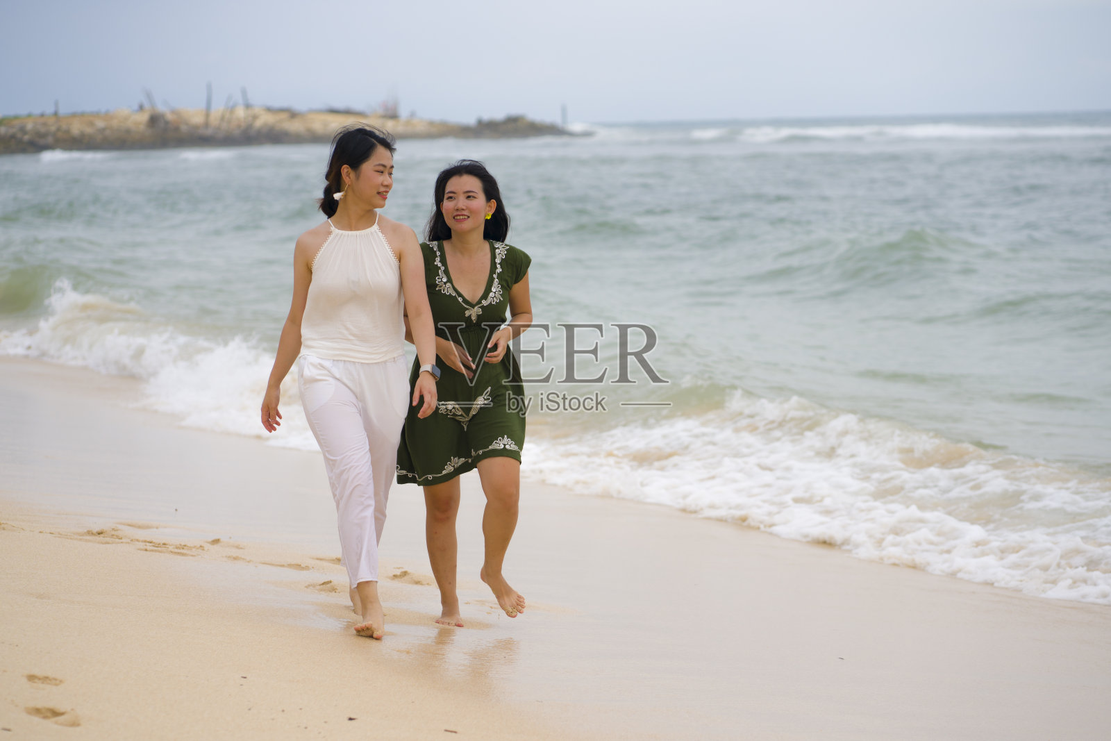 年轻美丽和幸福的一对迷人的亚洲中国女人一起走在沙滩上放松享受假期,有乐趣,感觉自由和快乐的女孩友谊概念照片摄影图片