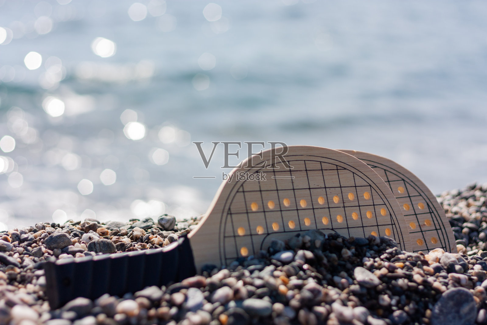 沙滩网球游戏设置,木制球拍的背景可拆卸海滩。照片摄影图片