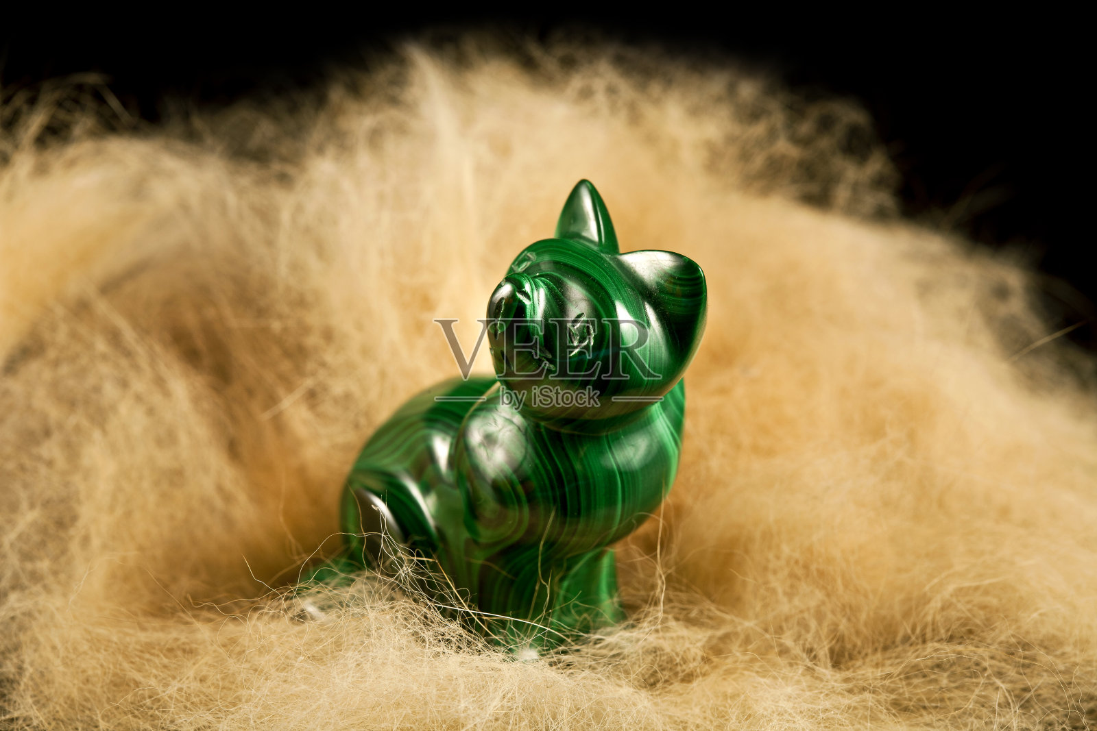 姜黄色猫咪与绿色宝石猫雕像照片摄影图片