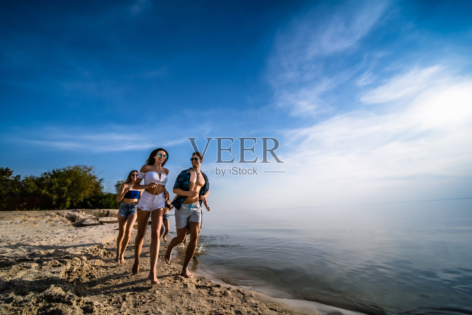 年轻人在海滩上慢跑照片摄影图片