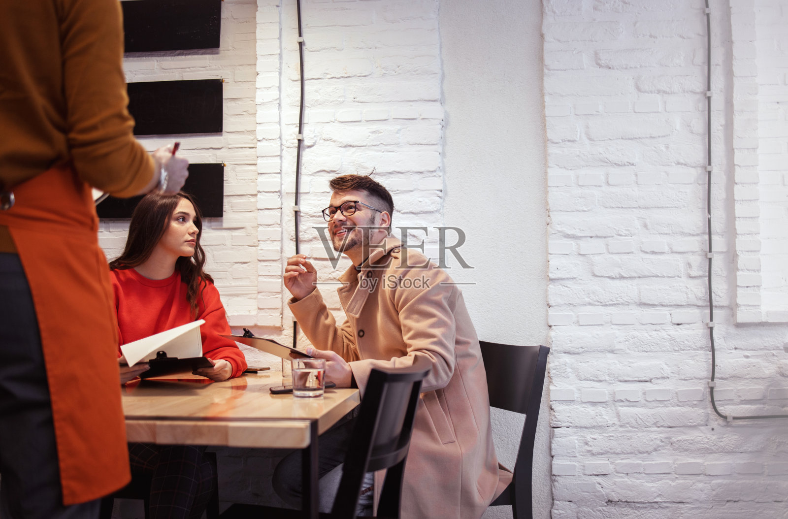 服务员为年轻夫妇点餐照片摄影图片