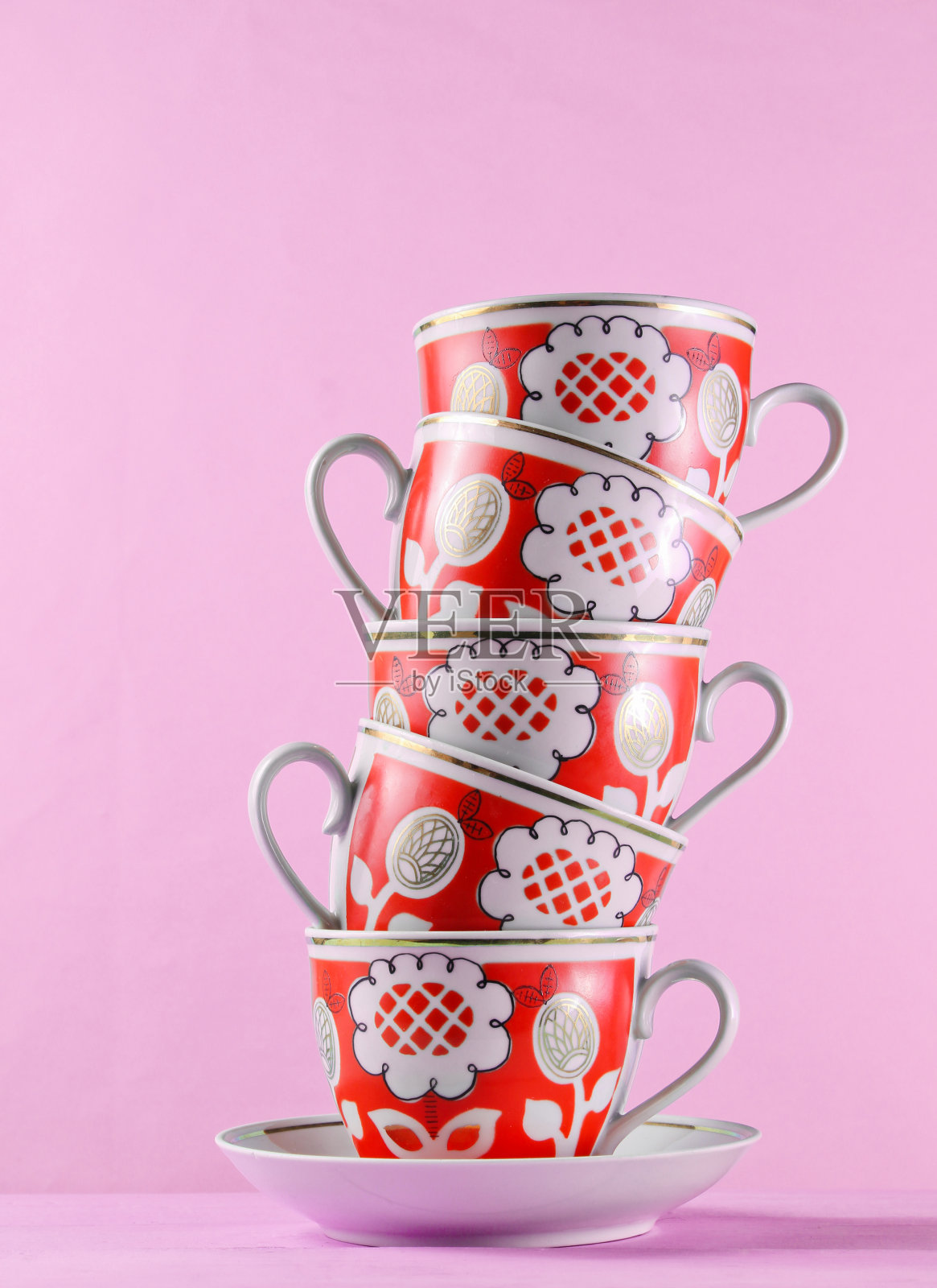 粉红色墙边的木桌上放着一堆古董陶瓷杯子照片摄影图片