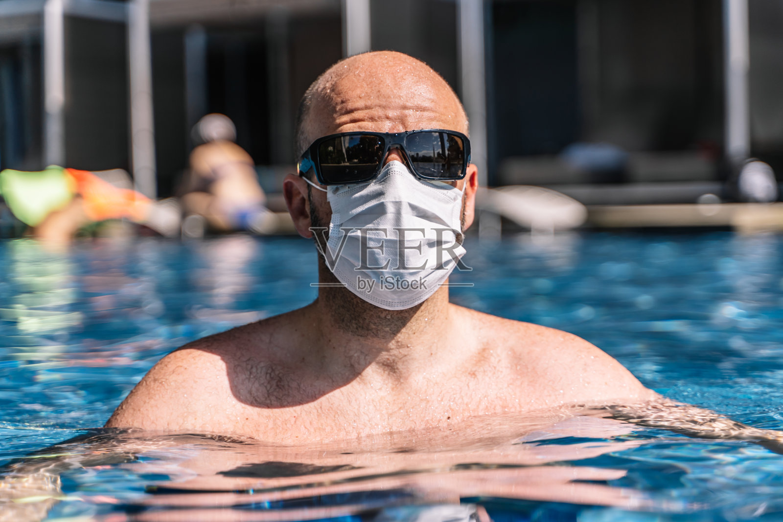 在游泳池里戴着呼吸面罩,担心感染新冠病毒的男游客肖像照片摄影图片