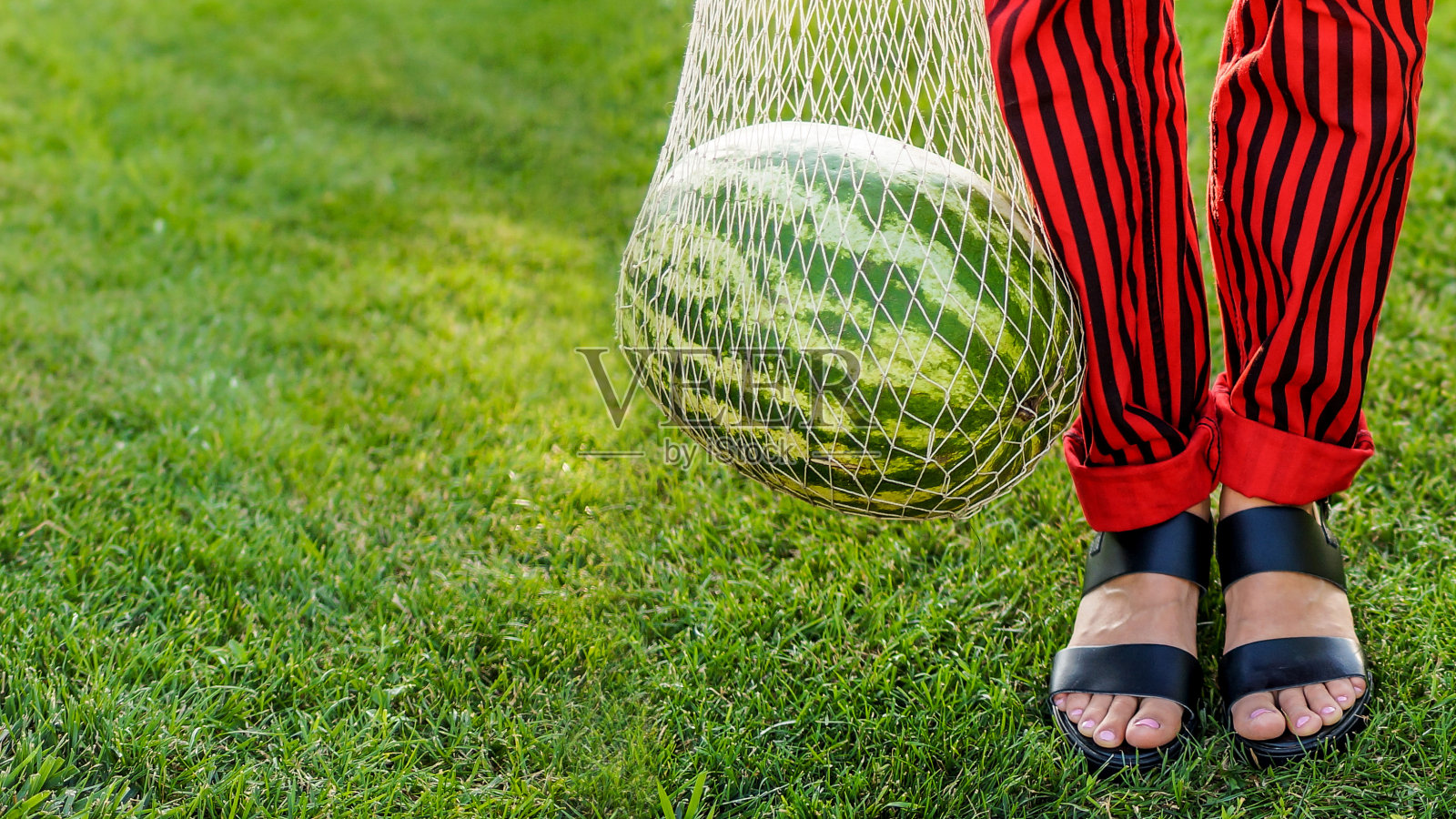 女人的腿和网袋里的西瓜照片摄影图片