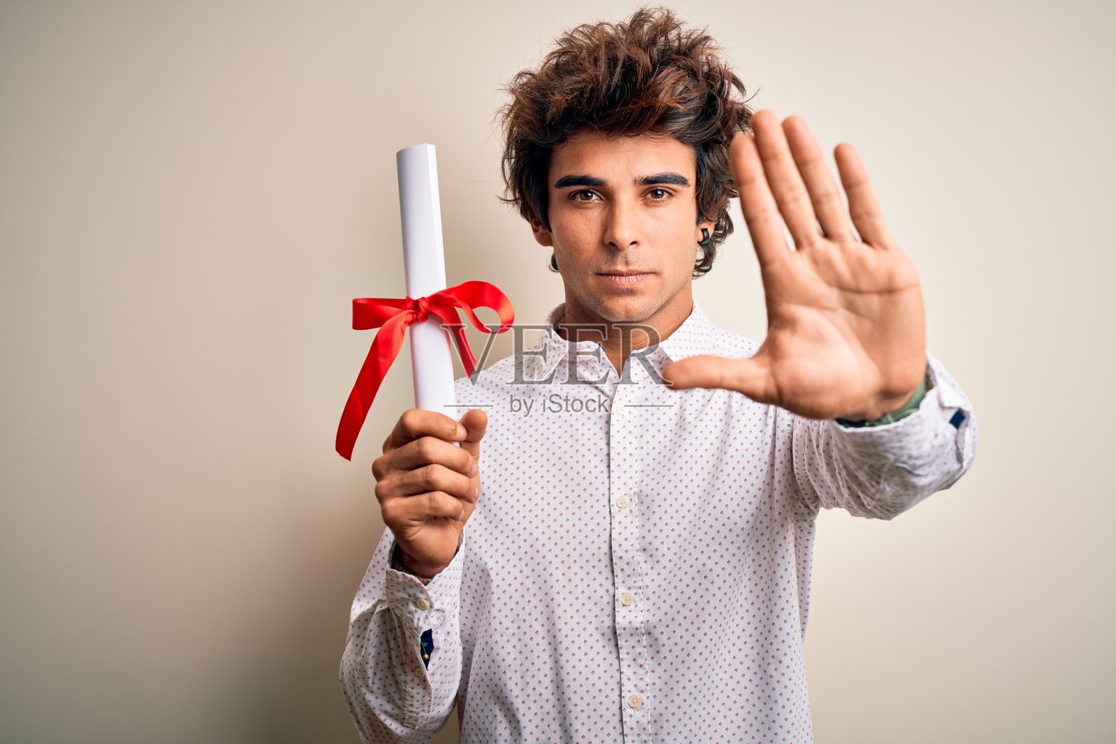 年轻英俊的学生男子拿着文凭站在孤立的粉红色背景与开放的手做停止标志与严肃和自信的表情,防御手势照片摄影图片