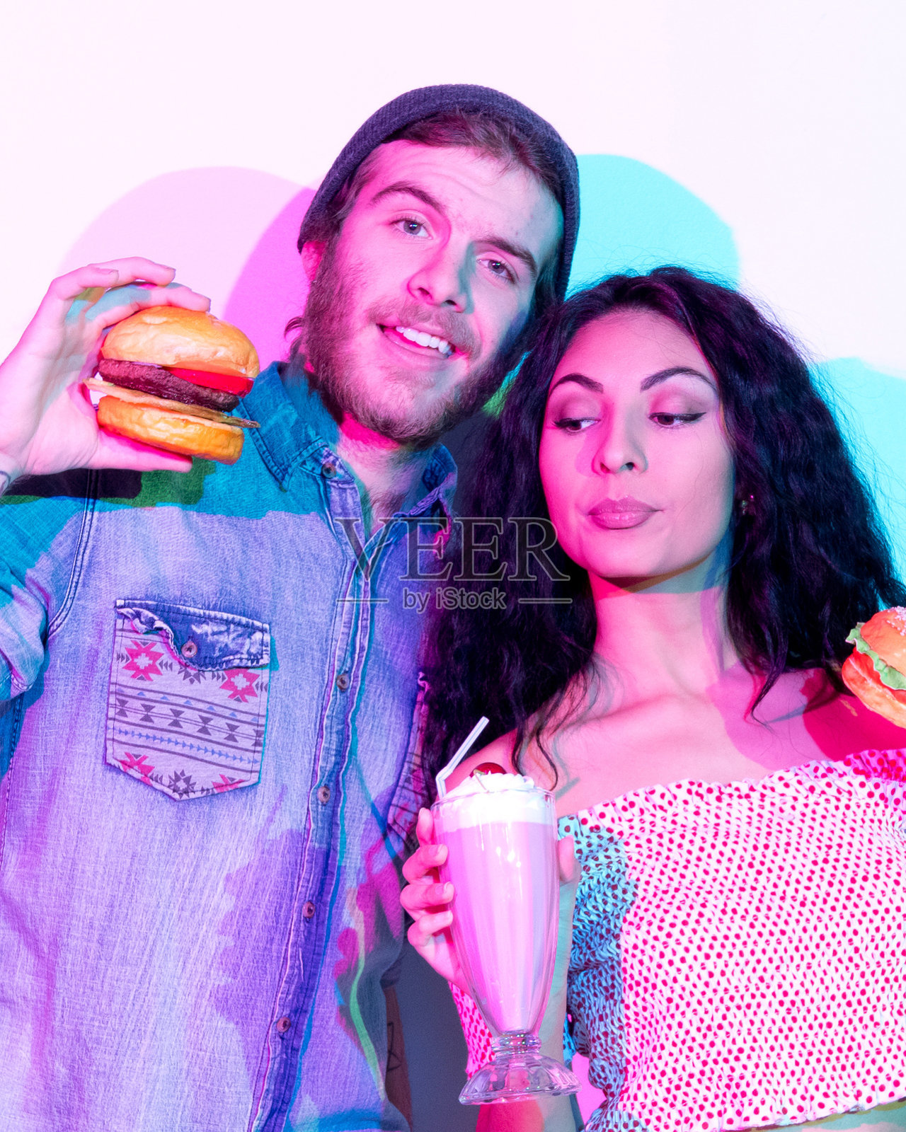 年轻的男性潮人戴着针织帽,拿着冰沙照片摄影图片