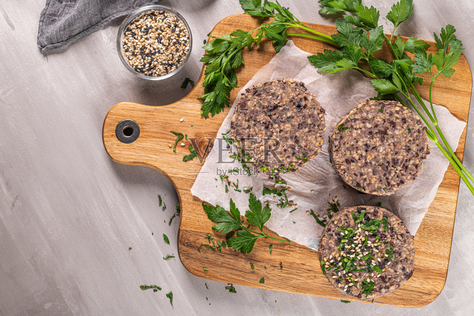 木台面上的黑豆生蔬菜汉堡。照片摄影图片