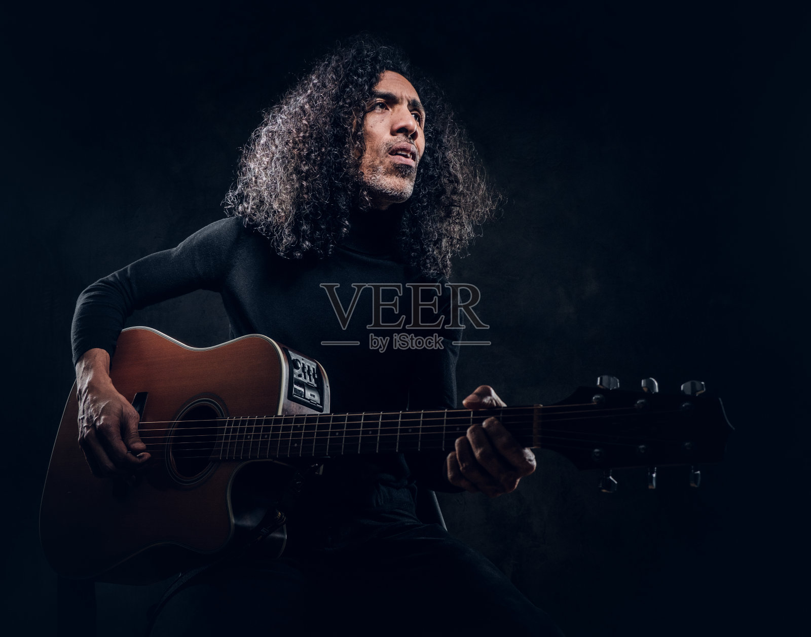 男人在为摄影师摆姿势时弹吉他照片摄影图片