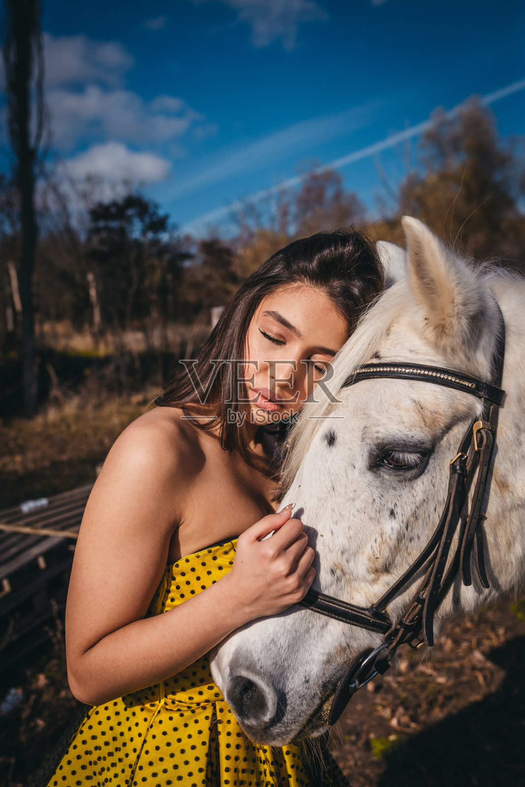 身穿黑色外套的年轻女孩骑着白马照片摄影图片