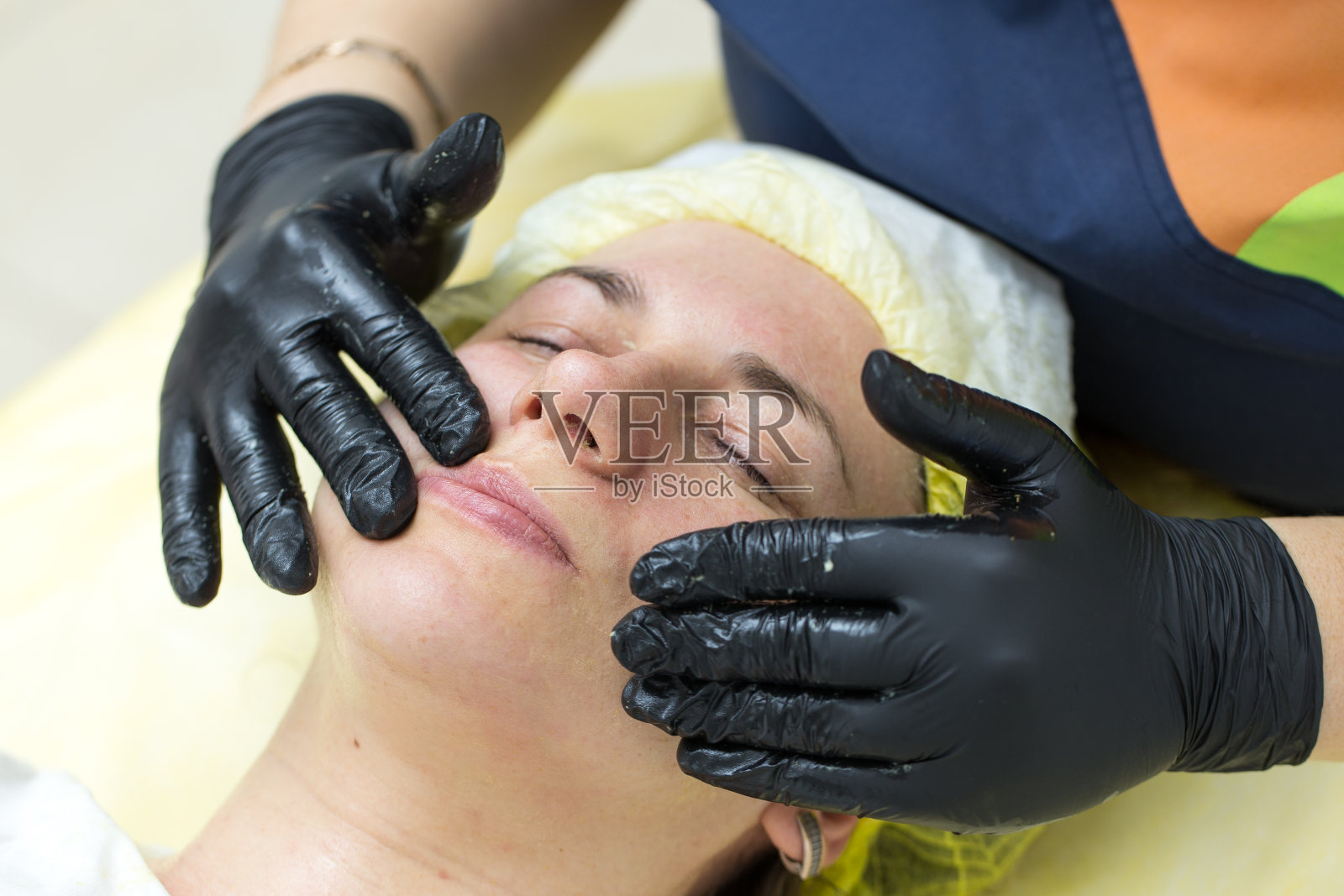 美容师按摩女性面部皮肤的手照片摄影图片