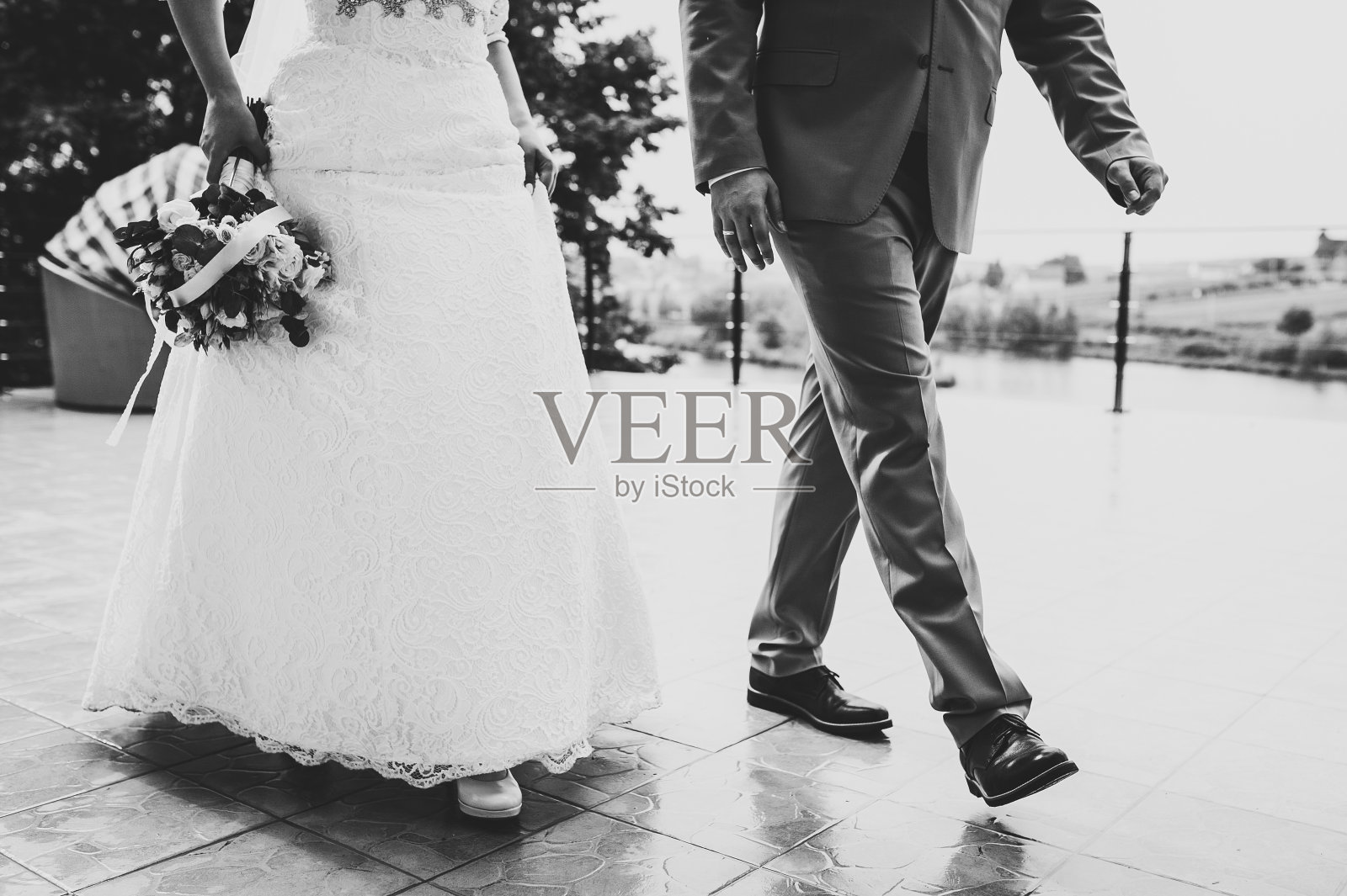 腿部特写:码头上婚礼仪式后的新娘和新郎。黑白照片,由下往上拍摄。照片摄影图片