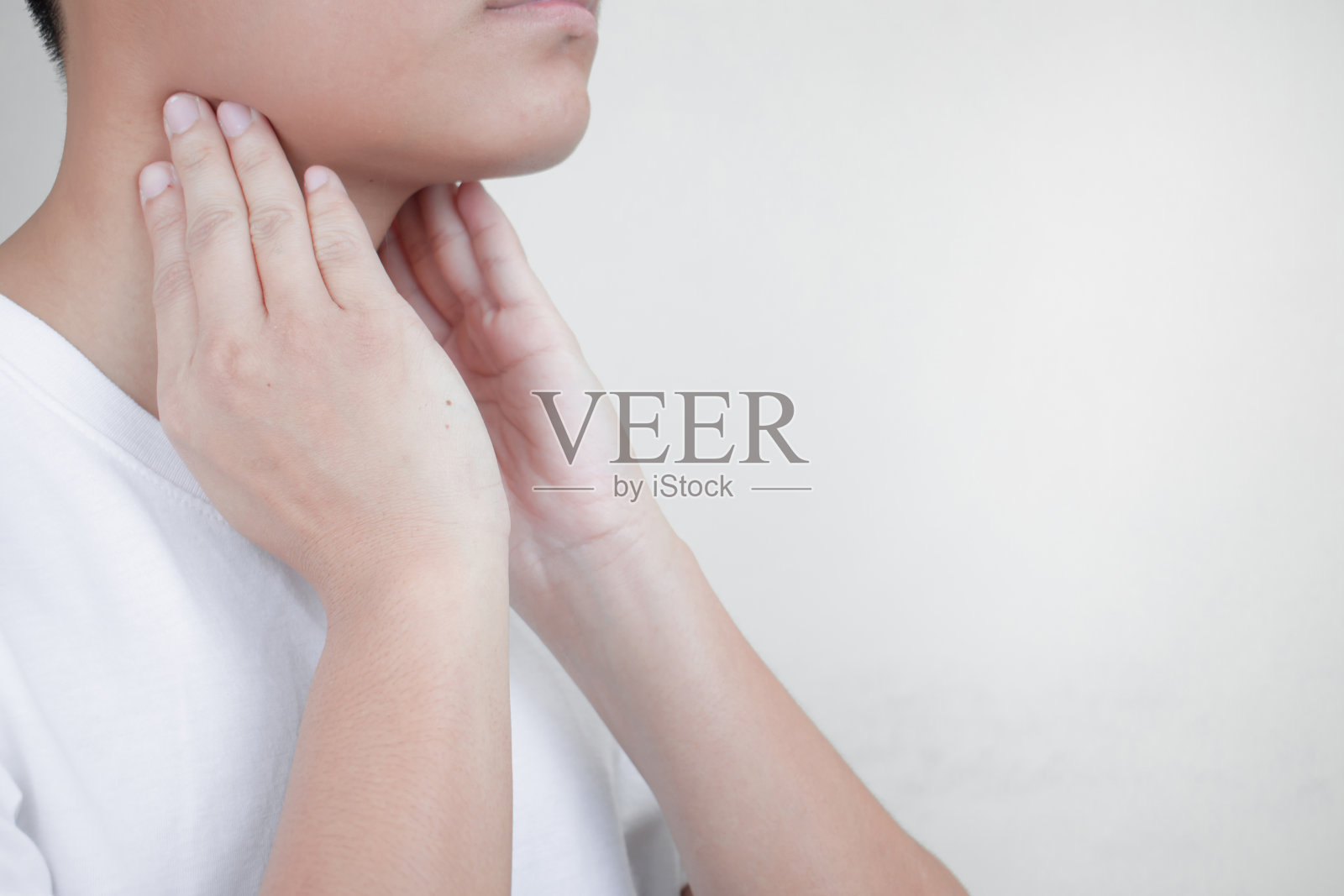 嗓子疼,因气候变化而捂住脖子的人。健康概念。照片摄影图片