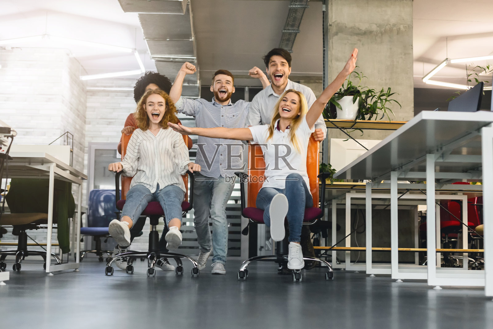 在办公室里玩得很开心的同事们举办椅子比赛照片摄影图片