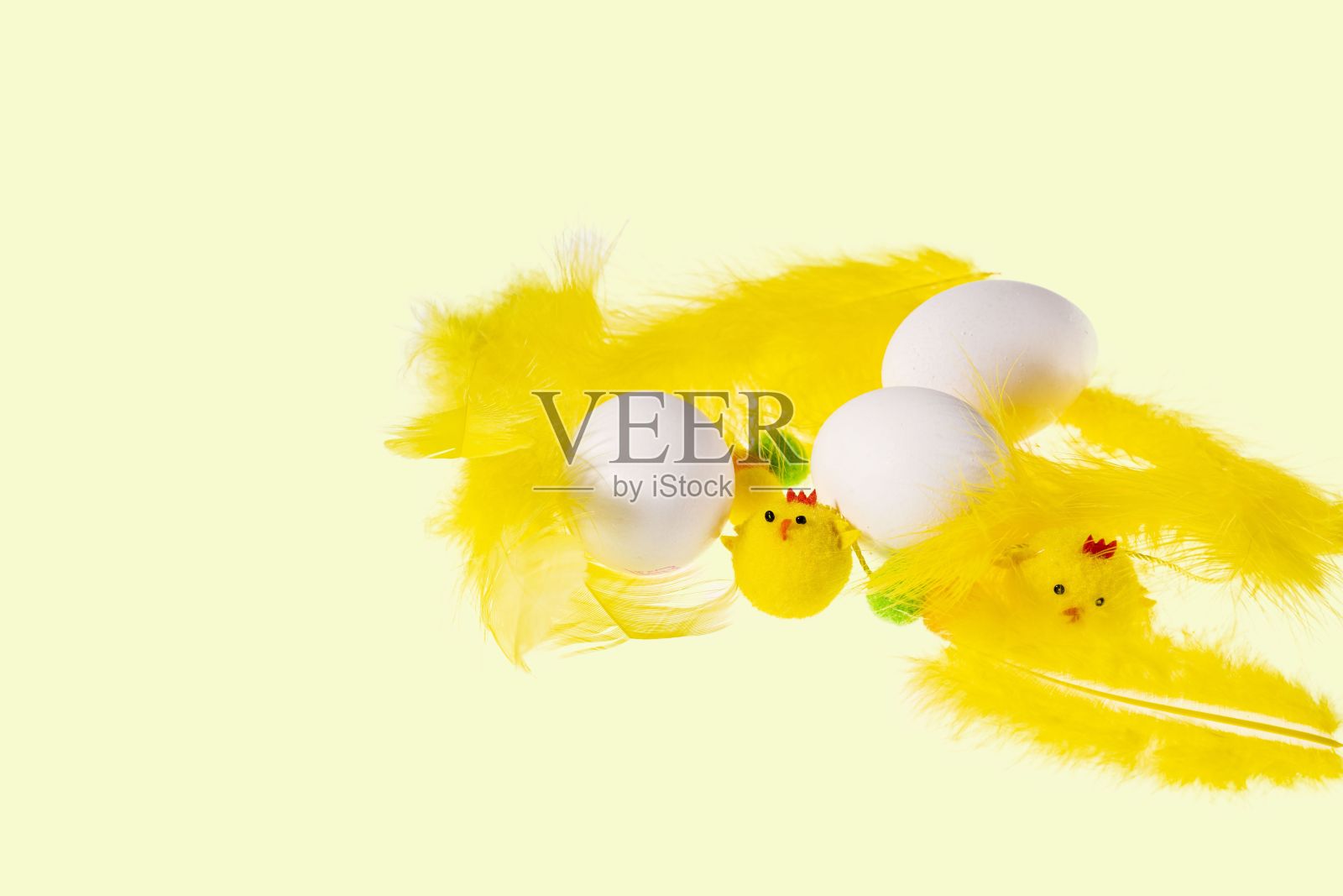近距离观察白色的蛋,黄色的羽毛和小鸡孤立在黄色的背景。复活节的概念。照片摄影图片