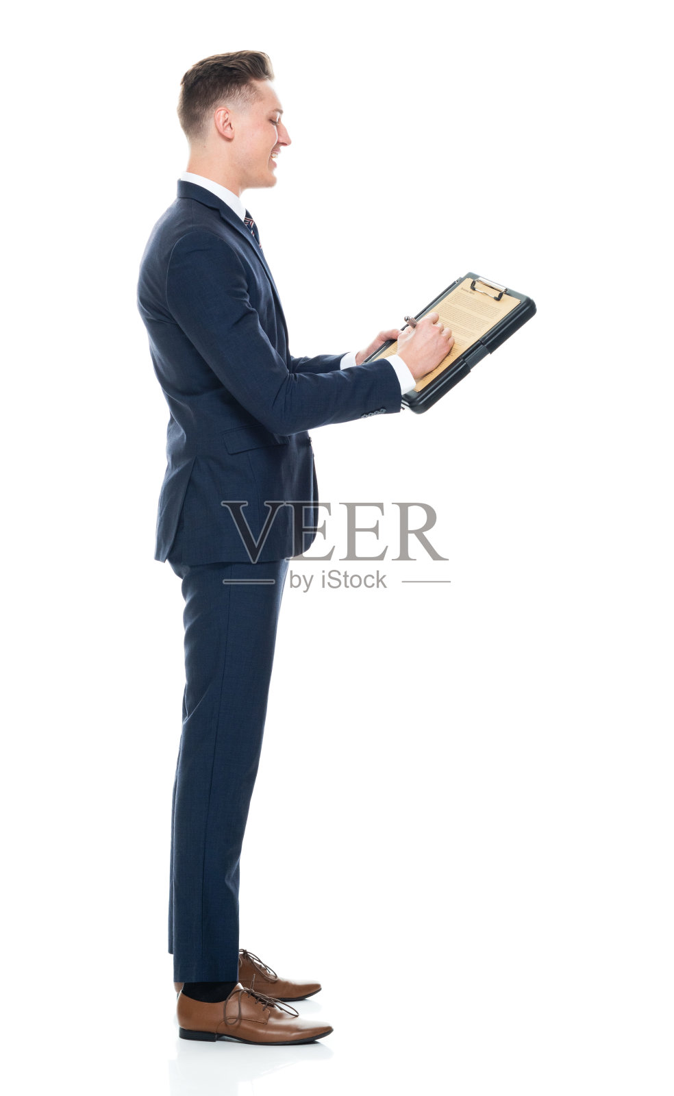 白人年轻男性商务人士站在白色背景下,穿着商务服装,拿着做清单照片摄影图片