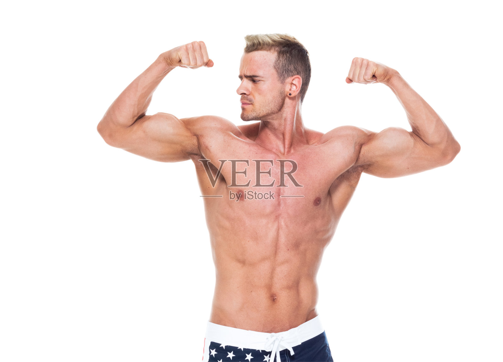 白人男性运动员穿着短裤站在白色背景前,积极锻炼身体,举着旗子照片摄影图片