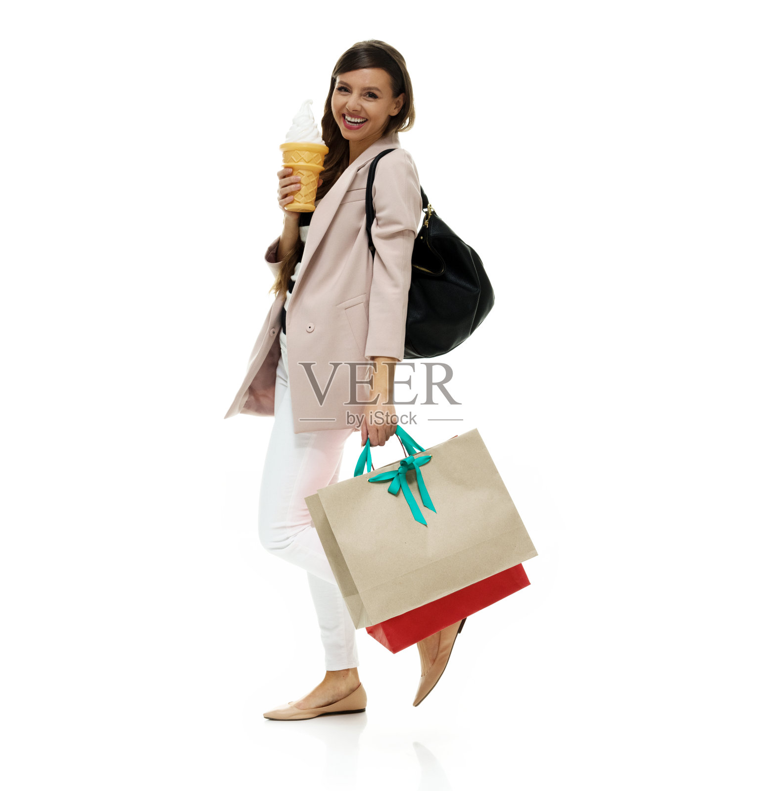 穿外套的年轻白人女性在白色背景前拿着冰淇淋照片摄影图片