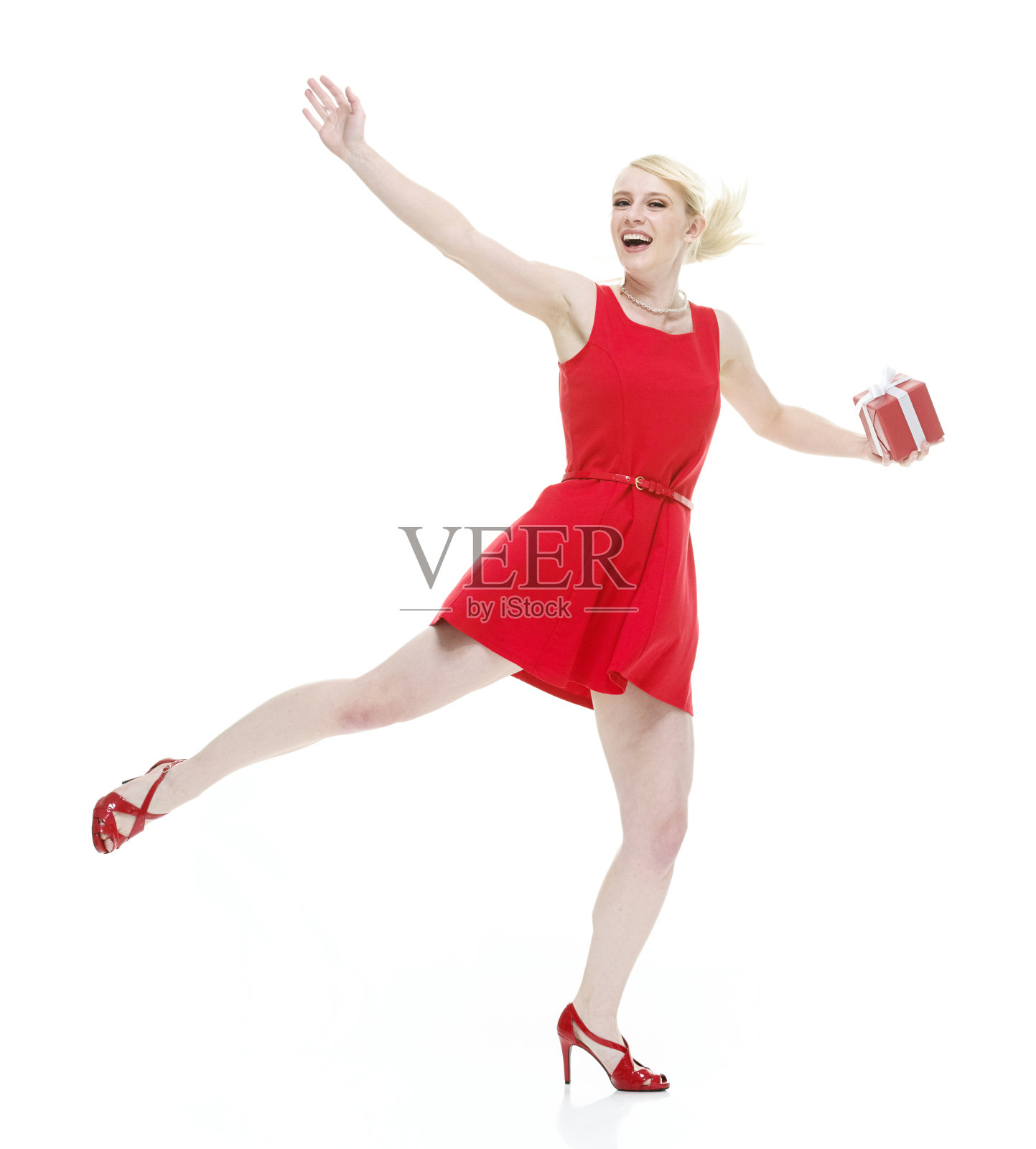 白人年轻女性穿着裙子,拿着盒子在白色背景前跳舞照片摄影图片