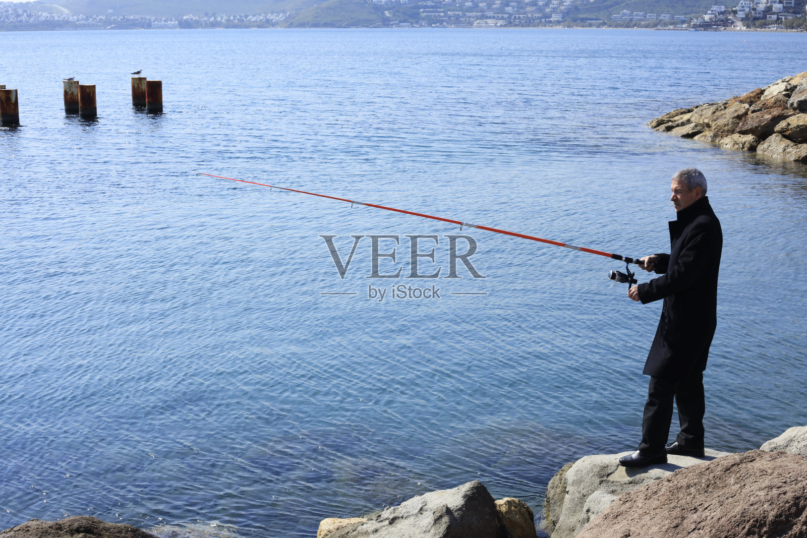 在海边钓鱼的年长男人照片摄影图片