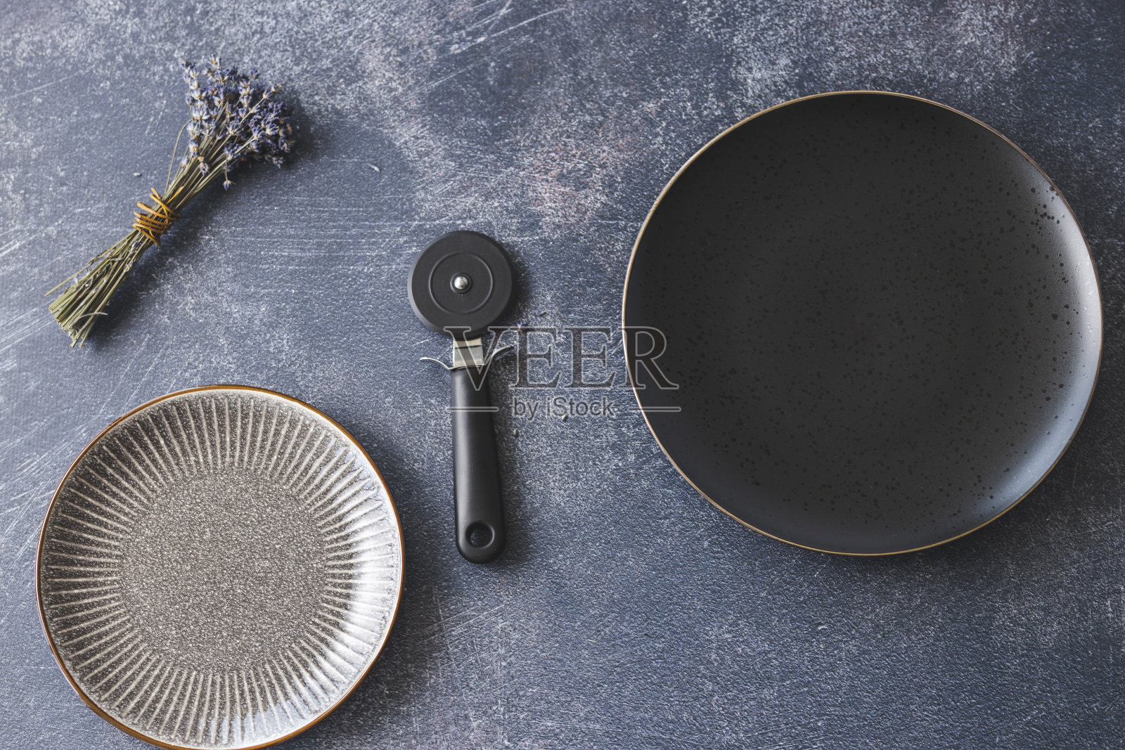 空盘子,披萨刀和薰衣草在黑暗的背景照片摄影图片