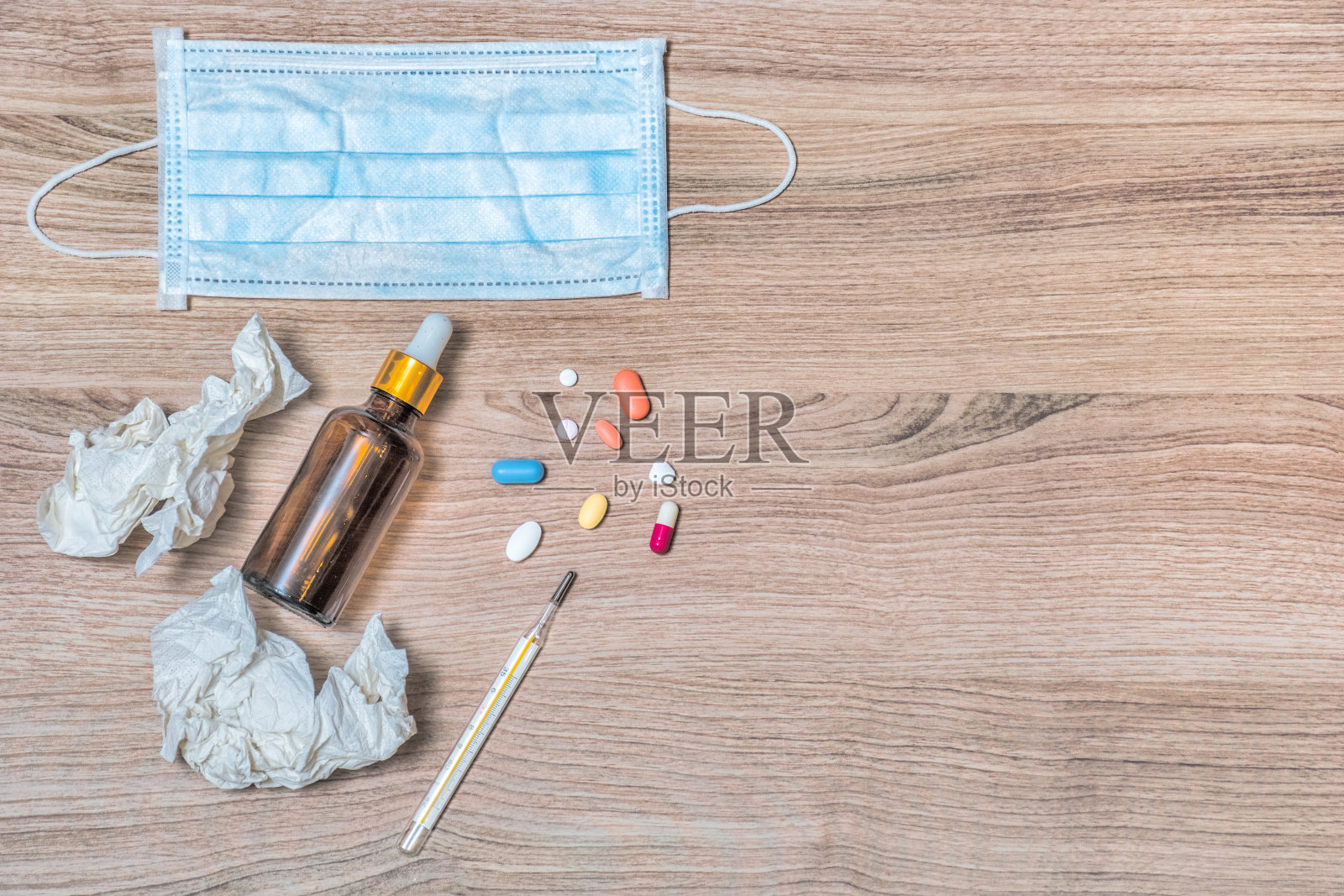 采购产品感冒和流感治疗,胶囊和药丸,医疗面具,杯茶,温度计,组织和口服液分离木质背景照片摄影图片
