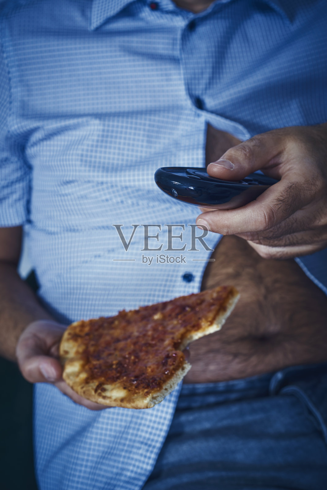 有啤酒肚的男人在吃披萨照片摄影图片