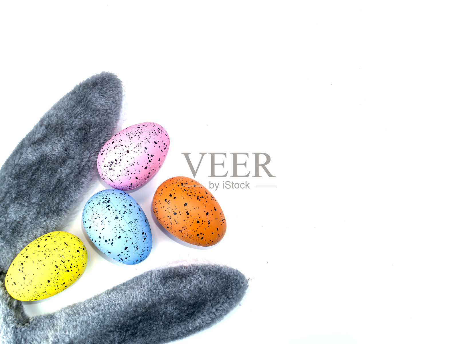 白色背景上的彩色复活节彩蛋和兔子耳朵。照片摄影图片