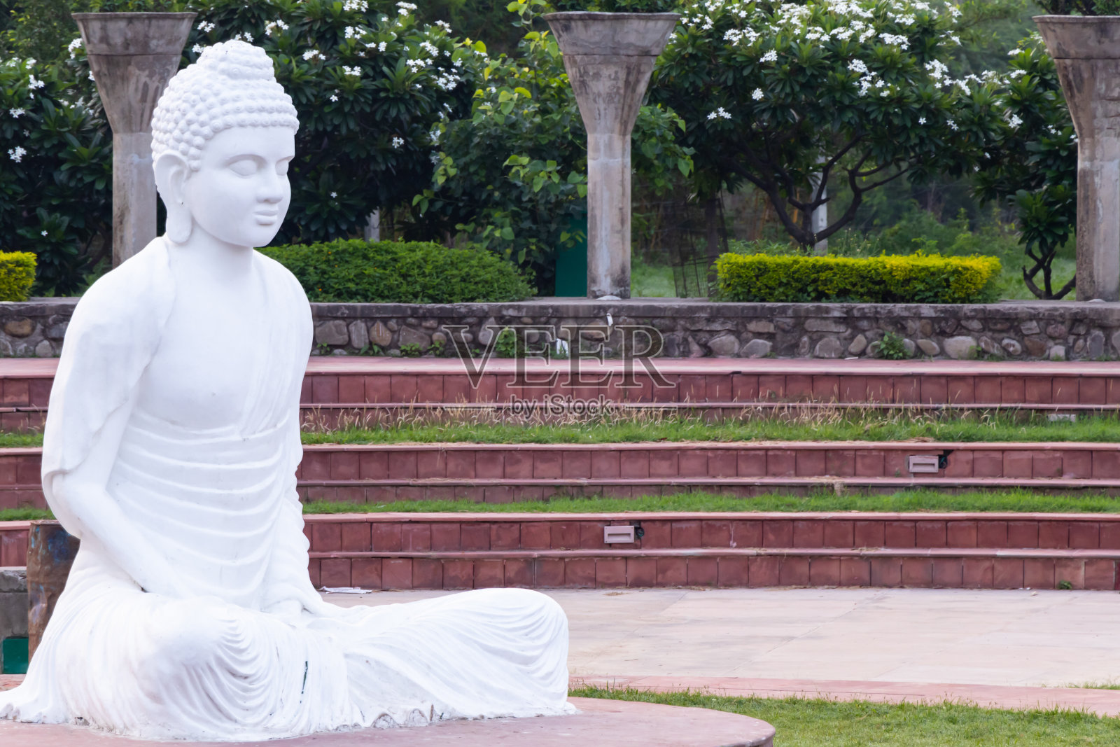 背景是奇怪水泥柱的白色佛像照片摄影图片