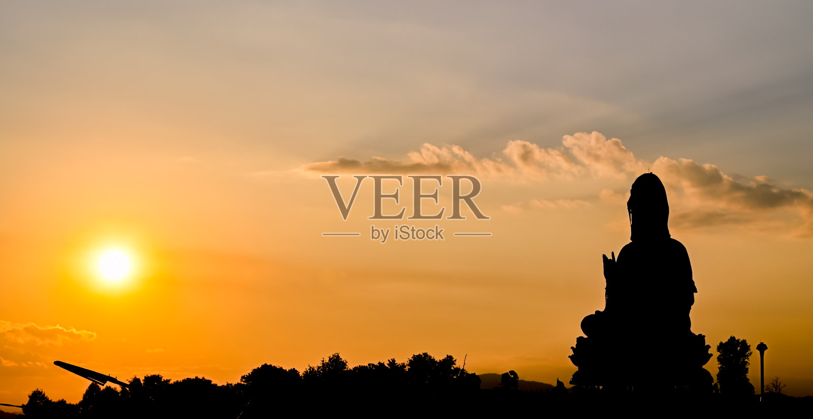 日落时分,泰国清莱省怀Pla康寺的大观音雕像剪影。照片摄影图片