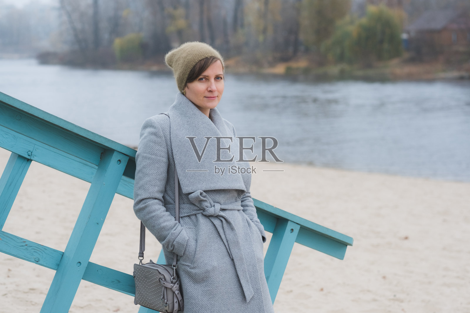 年轻女子穿着灰色外套独自走开照片摄影图片