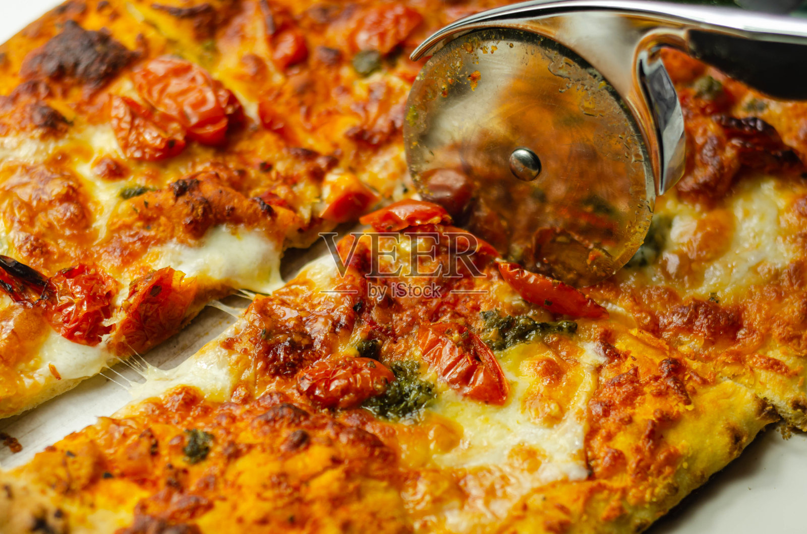 用切披萨刀切以水牛奶酪和西红柿为原料的著名那不勒斯披萨照片摄影图片