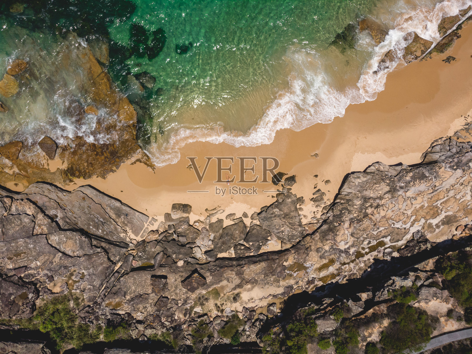 俯视图无人机空中隐蔽的海滩与绿松石水域周围的岩石形成照片摄影图片